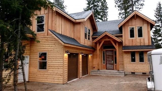 a large wooden house sitting in the middle of a forest.