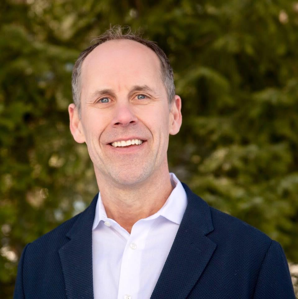 a man in a suit smiling for the camera.