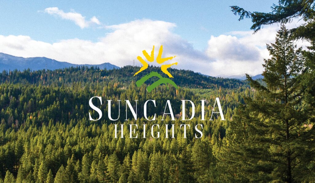 the suncadia heights sign is surrounded by pine trees.