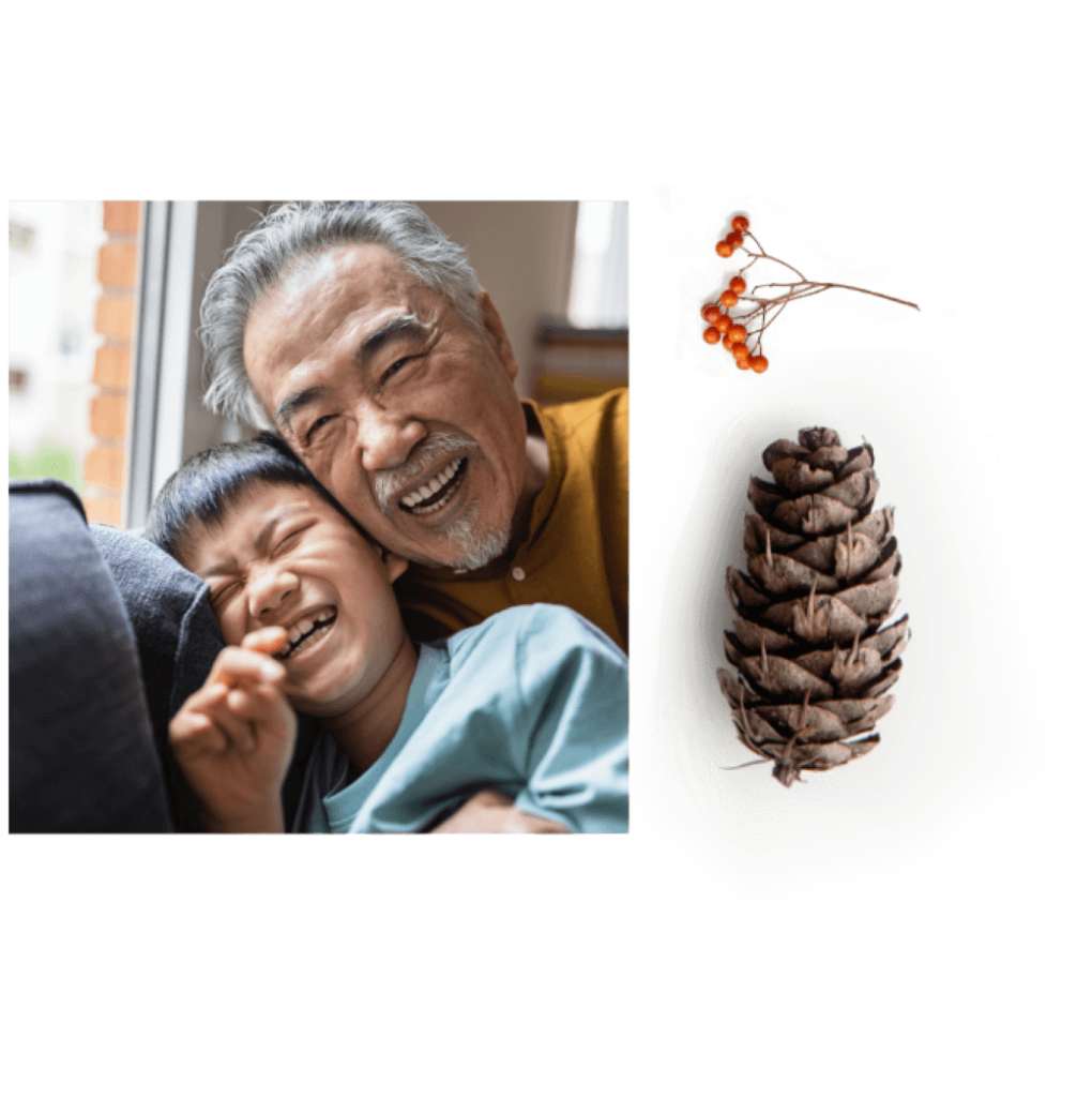 An elderly man and a child share laughter indoors at Suncadia Resort, Washington. A pine cone is displayed to their right, reminiscent of the natural beauty surrounding Cle Elum restaurants nearby.