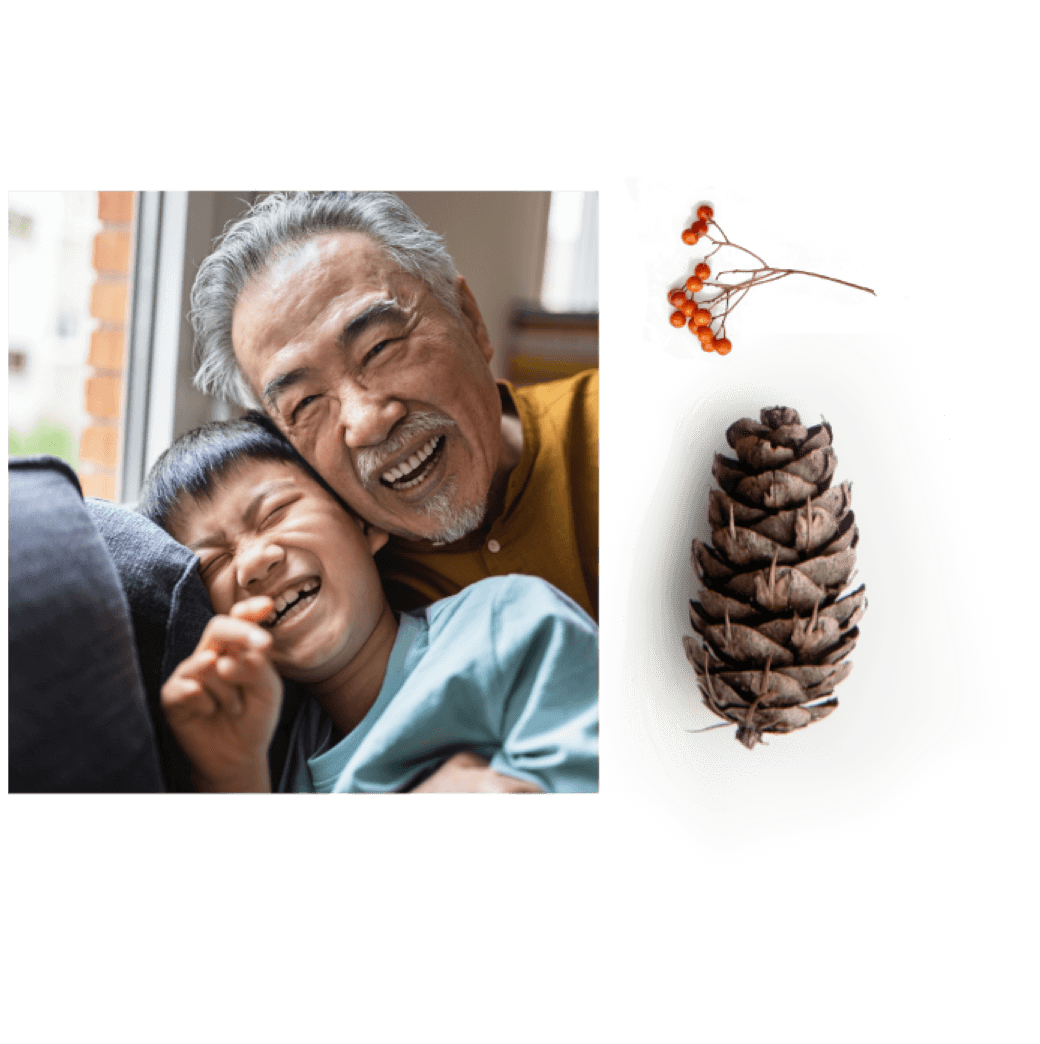 An elderly man and a child share laughter indoors at Suncadia Resort, Washington. A pine cone is displayed to their right, reminiscent of the natural beauty surrounding Cle Elum restaurants nearby.