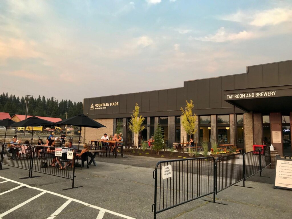 a group of people sitting at tables outside of a building.