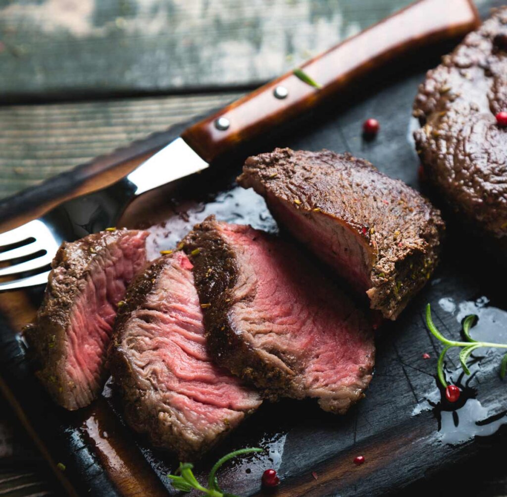 a close up of a steak on a cutting board.