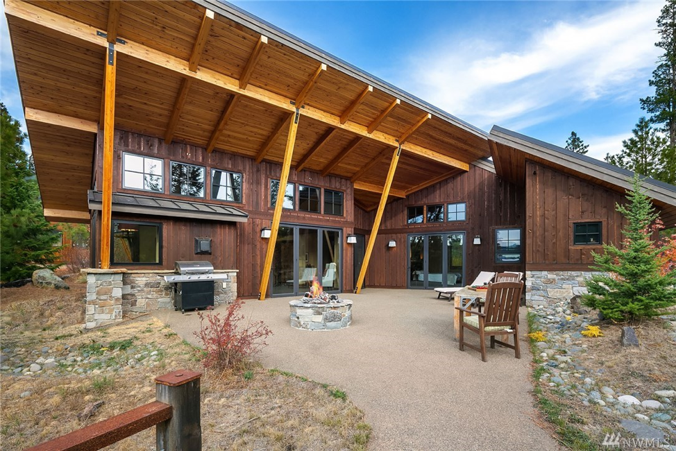 a large wooden building with a fire pit in front of it.