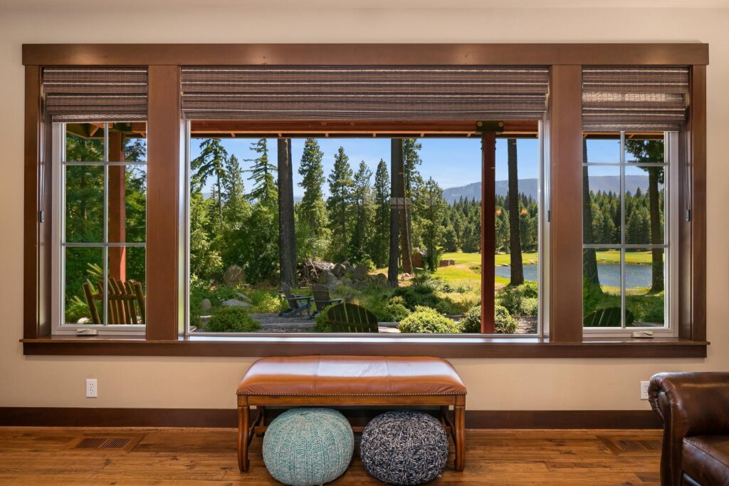 a living room with a large window and a bench.