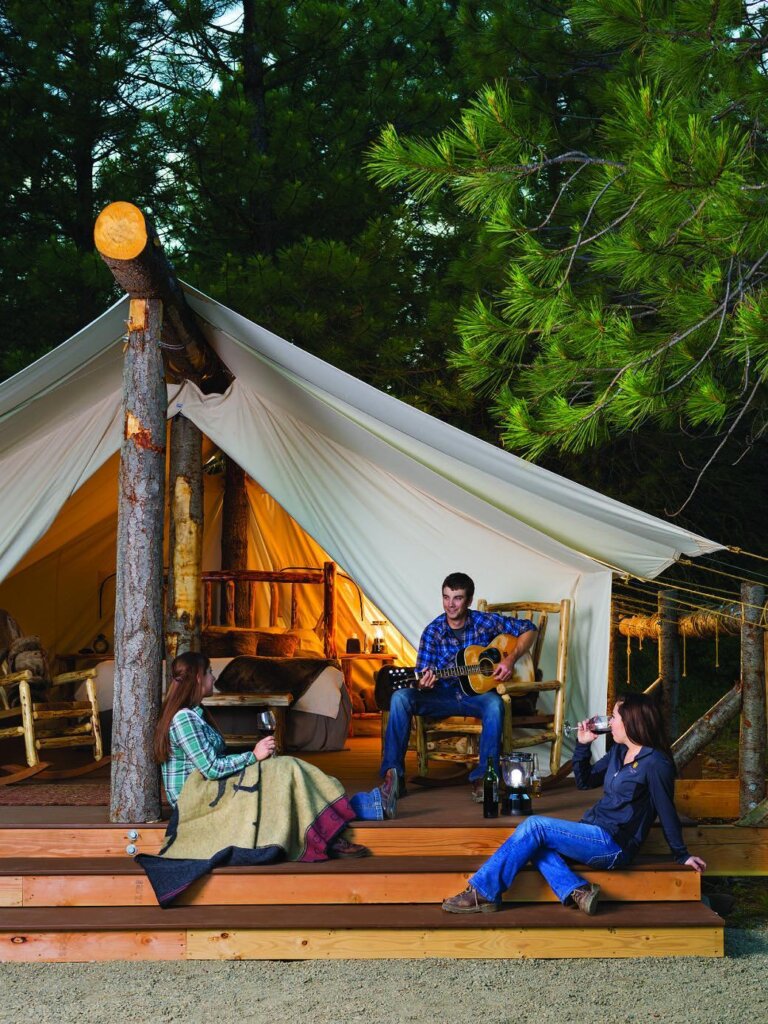 a group of people sitting outside of a tent.