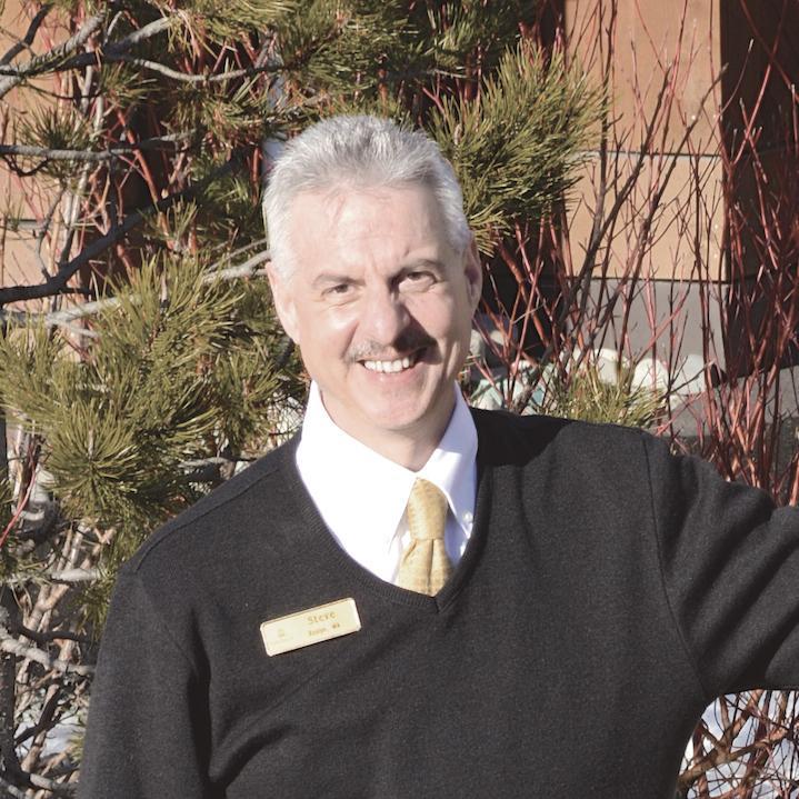 a man wearing a black sweater and a yellow tie.