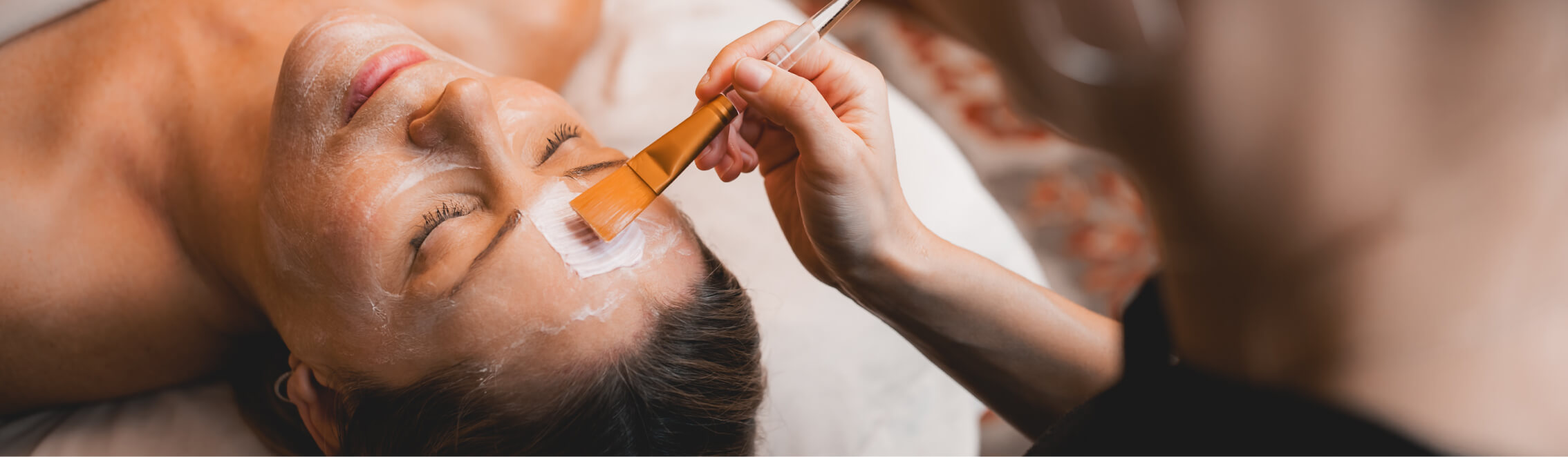 At Suncadia Resort in Washington, a person receives a relaxing facial treatment, with a cosmetician gently applying a mask using a brush on the forehead.