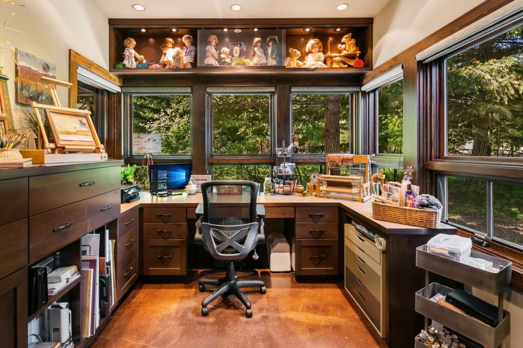 a home office with a lot of clutter on the desk.