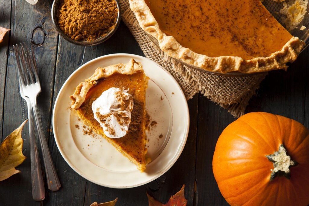 a slice of pumpkin pie on a white plate.