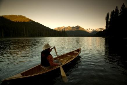 a person in a canoe paddling on a lake.