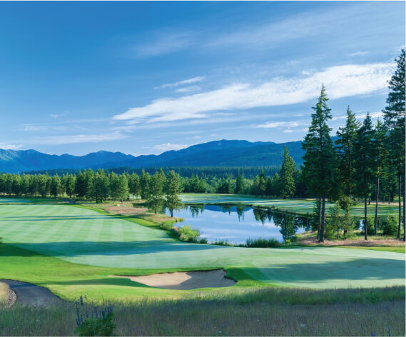 Nestled near Suncadia homes, this golf course features sand traps, lush green fairways, and a tranquil pond. Surrounded by towering trees and majestic mountains under a clear blue sky, it offers an idyllic setting for golfers to enjoy Suncadia's natural beauty.