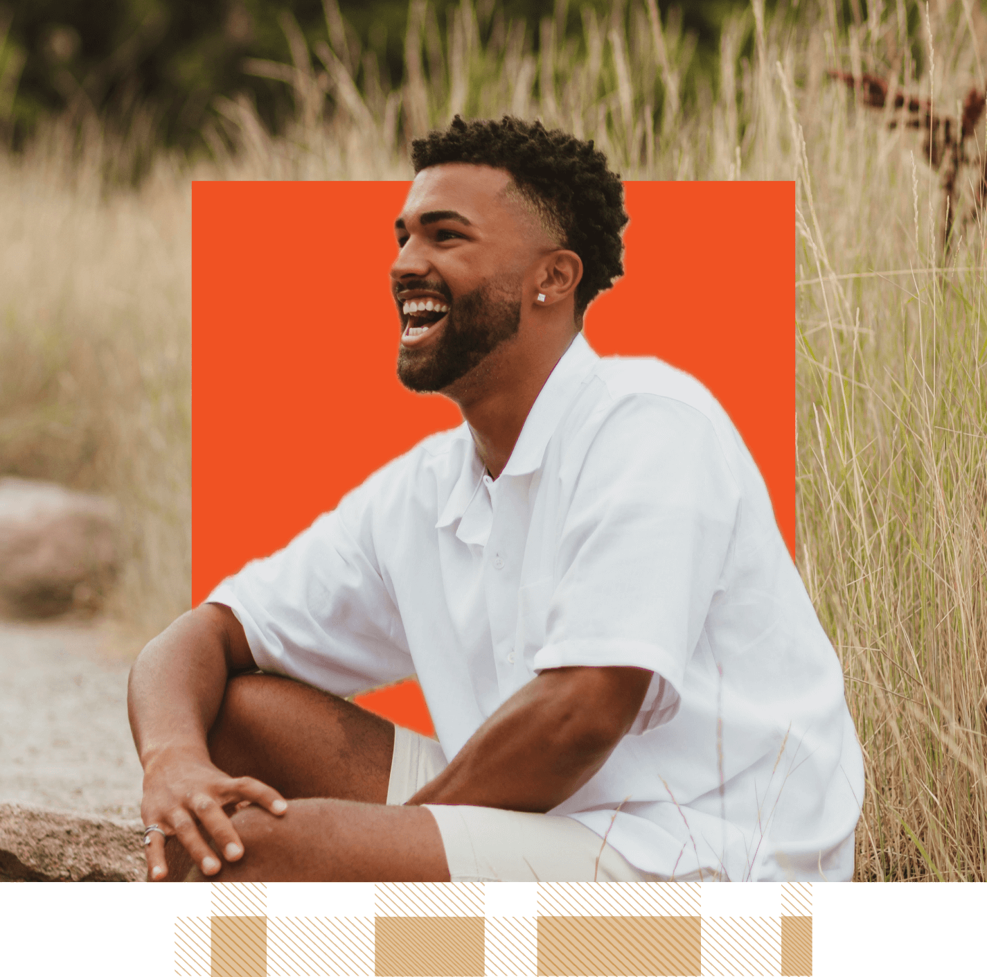 A man in a white shirt sits smiling outdoors at Suncadia Resort in Washington. The background features tall grass and an orange square, capturing the essence of the serene surroundings near Cle Elum restaurants.