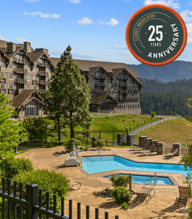 A mountain resort with lodge-style buildings overlooks a forested valley, featuring an outdoor pool area; a “25 Years Anniversary” badge is in the top right corner.