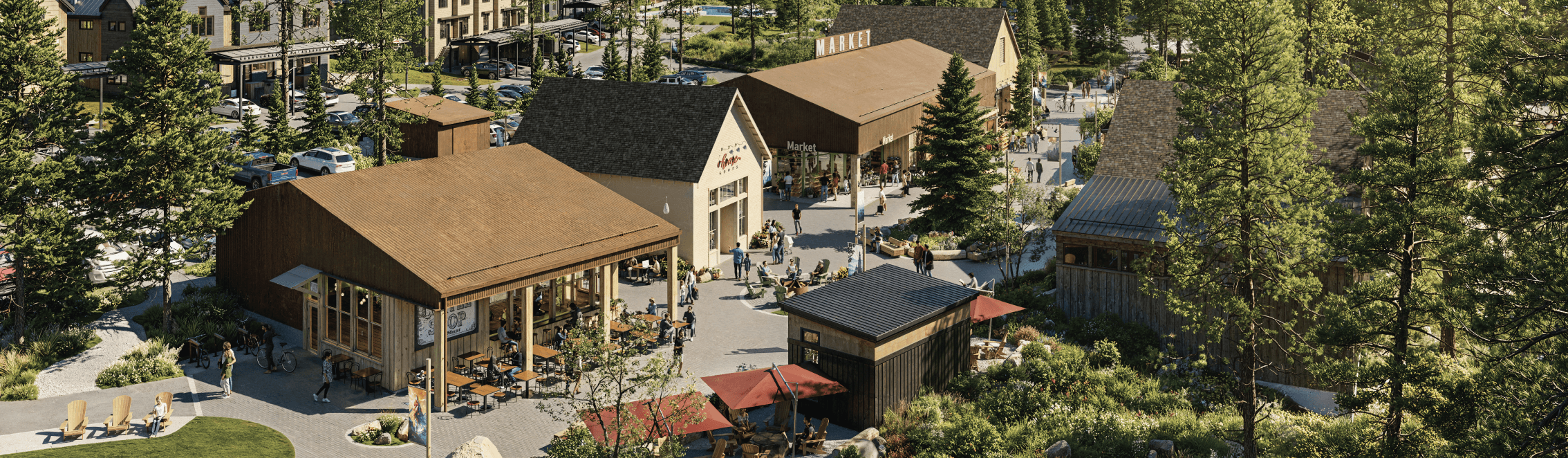 Aerial view of a small outdoor shopping and dining area surrounded by trees, featuring several buildings, tables, and people walking or seated.