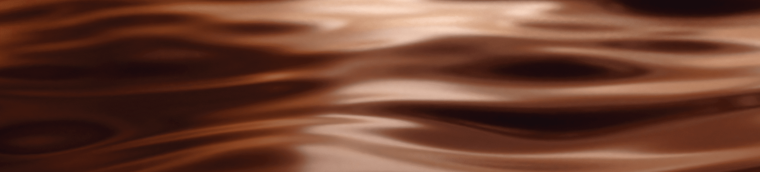 Brown liquid with smooth, wavy ripples and soft reflections, creating an abstract, fluid pattern.