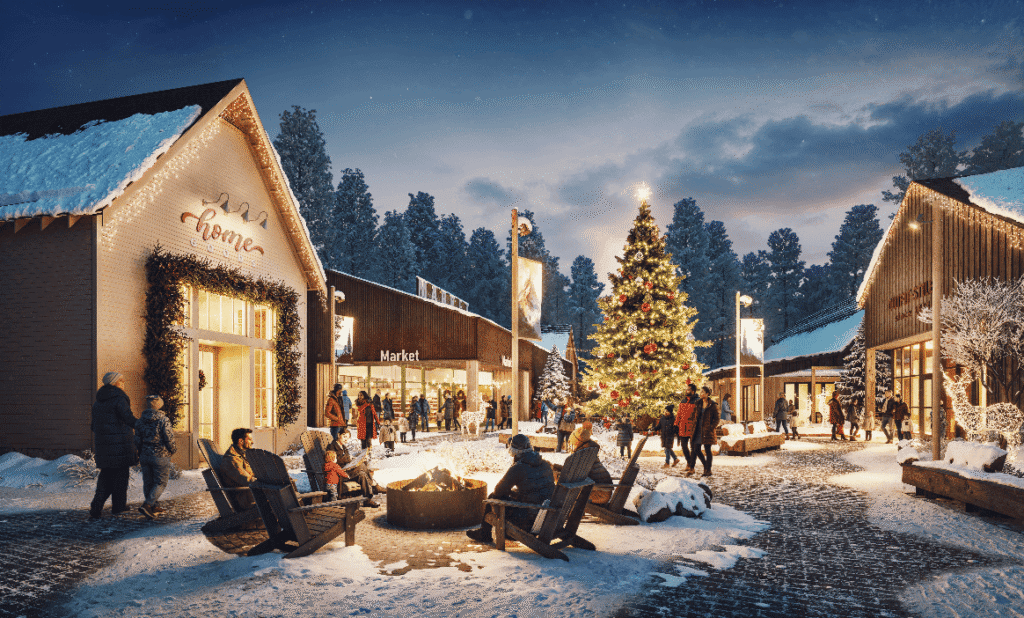 People sit around a fire pit in a snowy village square with decorated shops and a large Christmas tree, surrounded by festive lights in the evening.