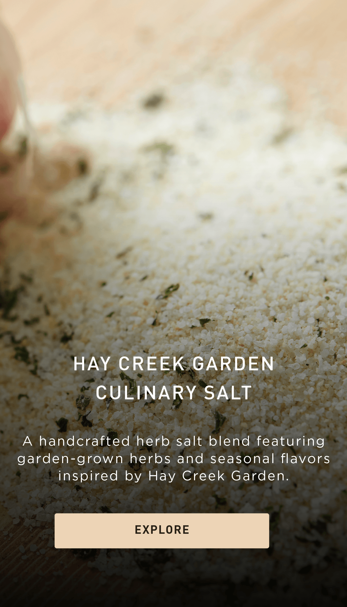 A close-up of a herb salt blend on a surface, featuring green herbs mixed with salt. Text reads: Hay Creek Garden Culinary Salt and describes it as a handcrafted blend with garden-grown herbs.