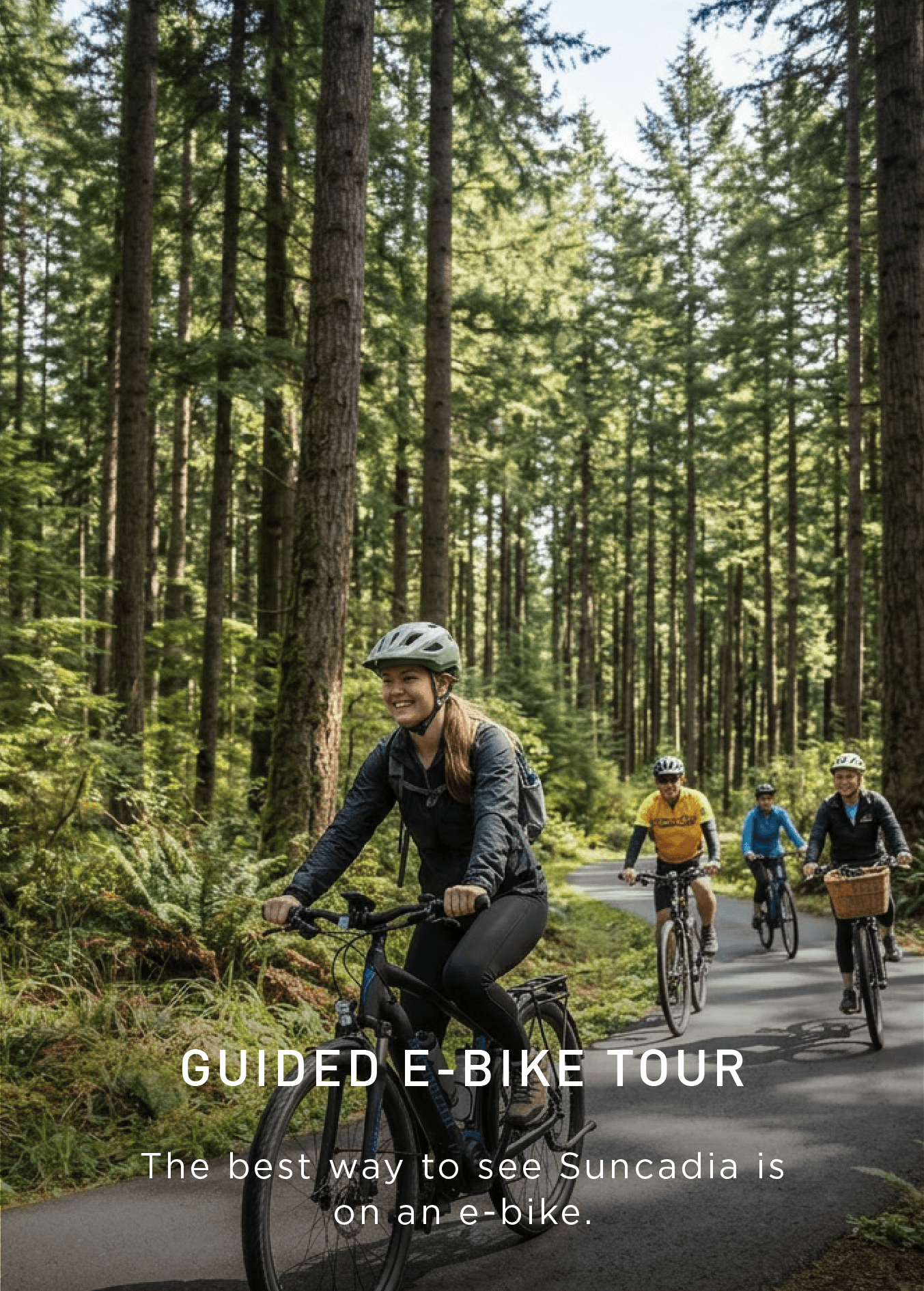 A group of people ride e-bikes on a paved forest trail, surrounded by tall trees and sunlight, with a woman smiling in the front. Text promotes a guided e-bike tour in Suncadia.