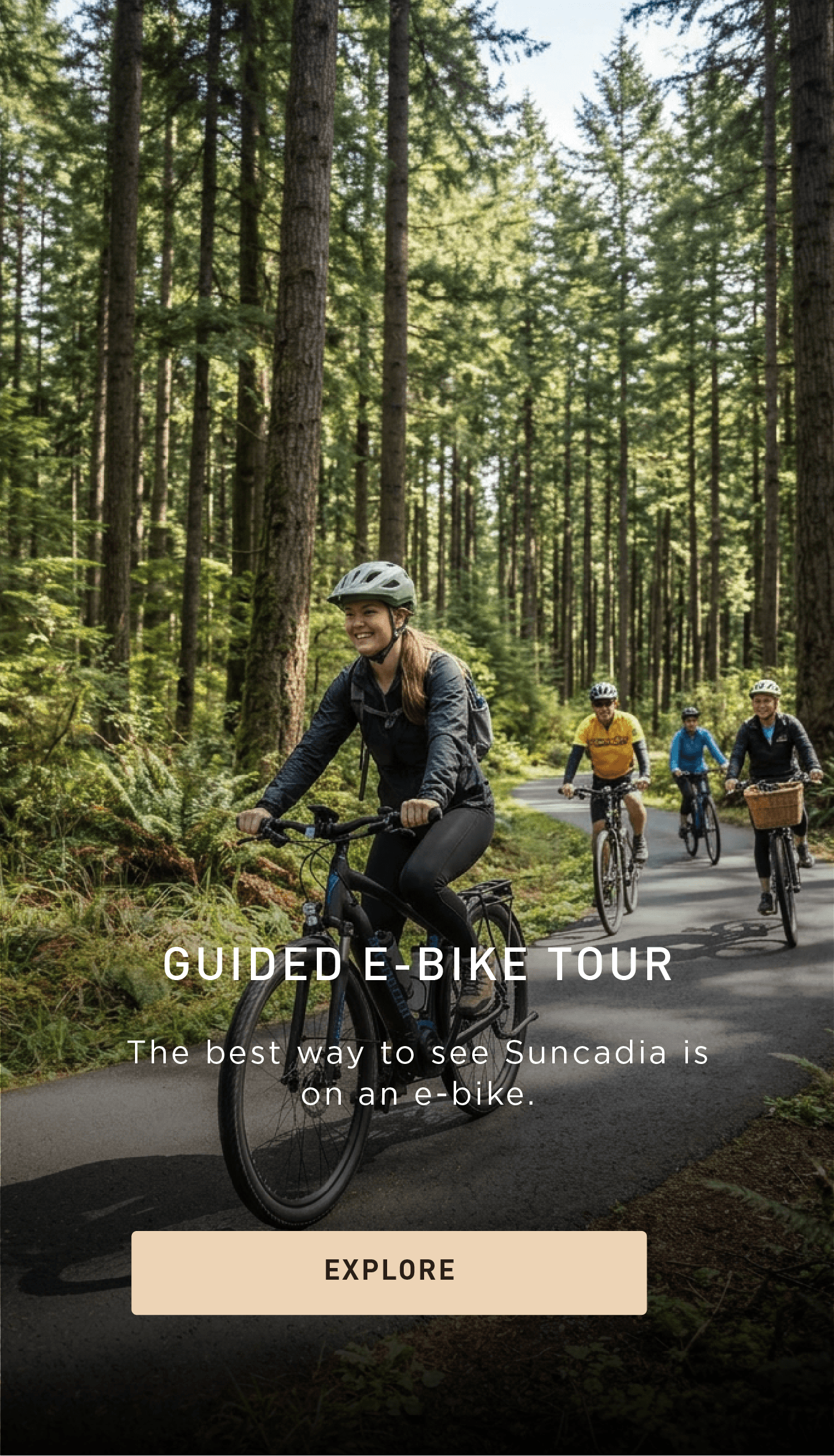A group of people ride e-bikes on a paved forest trail, surrounded by tall trees and sunlight, with a woman smiling in the front. Text promotes a guided e-bike tour in Suncadia.
